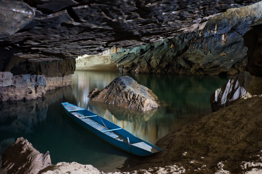 River and rock cliff, and rowing tourist boat inside of Phong Nha Cave in Phong Nha Ke Bang National Park, a UNESCO World Heritage Site in Quang Binh Province, Vietnam (2)